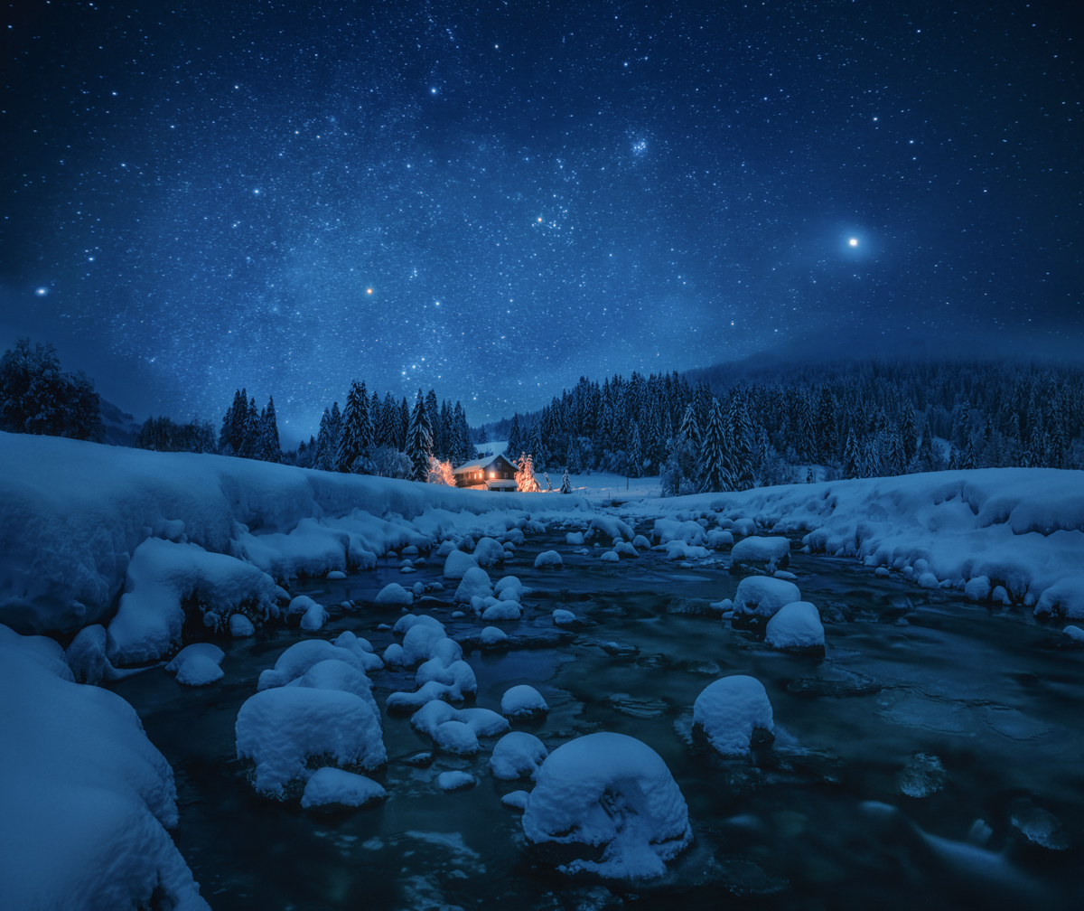 Winterzauber am Roormoos, Sternennacht über verschneitem Bergbach und beleuchteter Hütte, Weihnachtliche Nachtfotografie