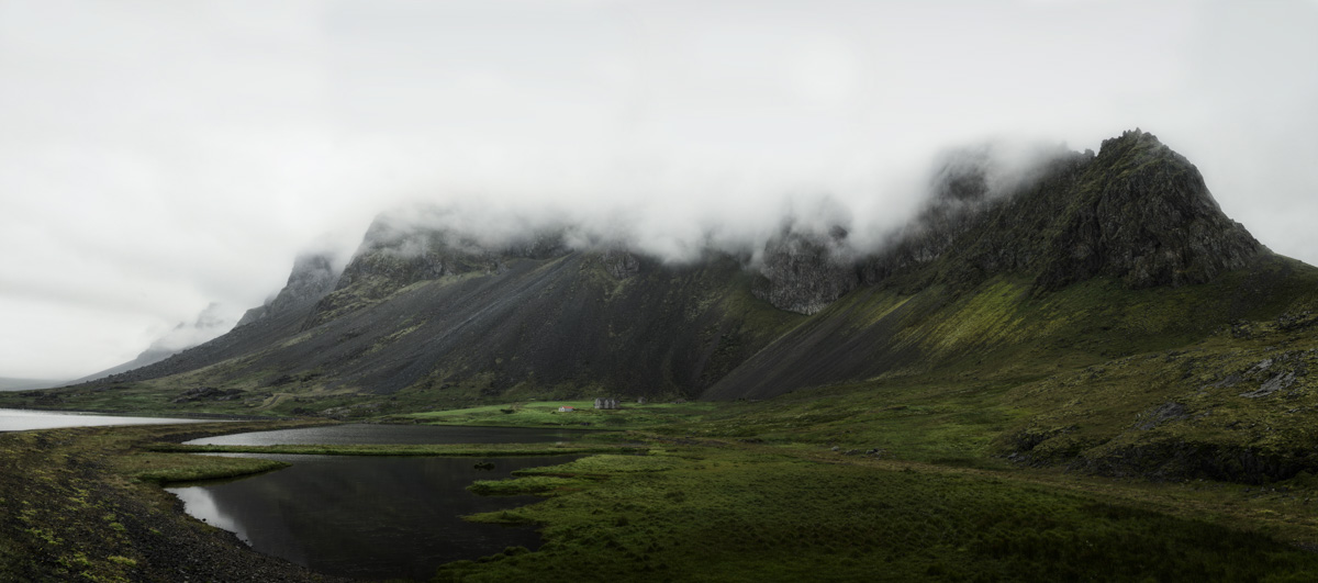 Nebelige Bergkette am Fjord, Wolkenverhangene Gipfel und grüne Wiesen, Mystisch - Landschaftsfotografie Island