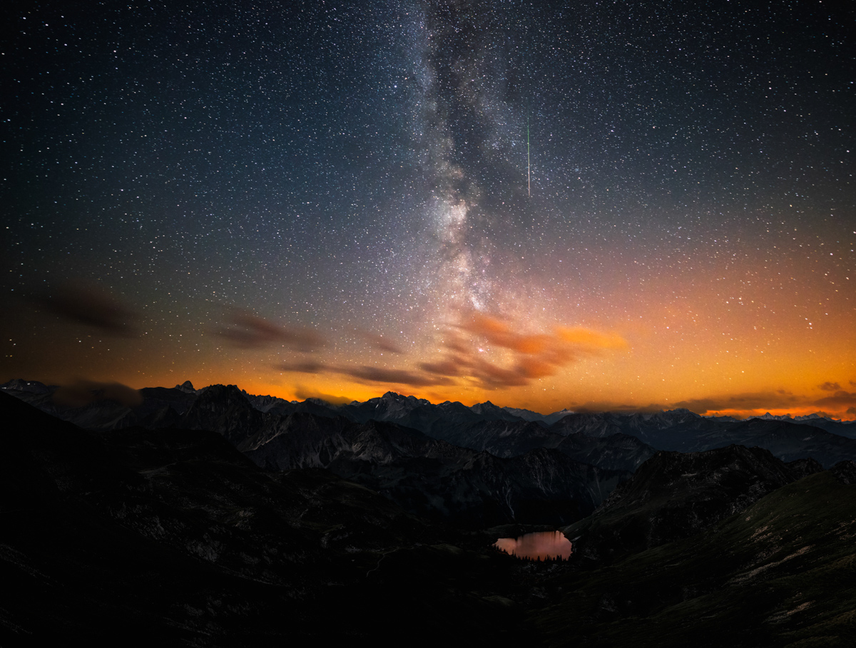 Milchstraße über dem Seealpsee am Nebelhorn, Bergsee mit Sternschnuppe und goldenem Horizontleuchten