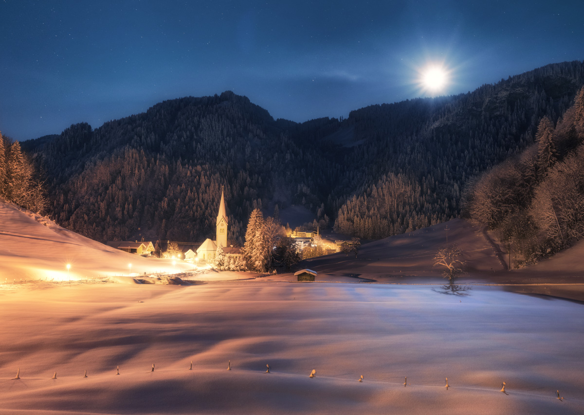 Vollmondnacht über Tiefenbach, Verschneites Bergdorf mit Kirche im Mondlicht, Winterzauber bei Oberstdorf - Nachtfotografie