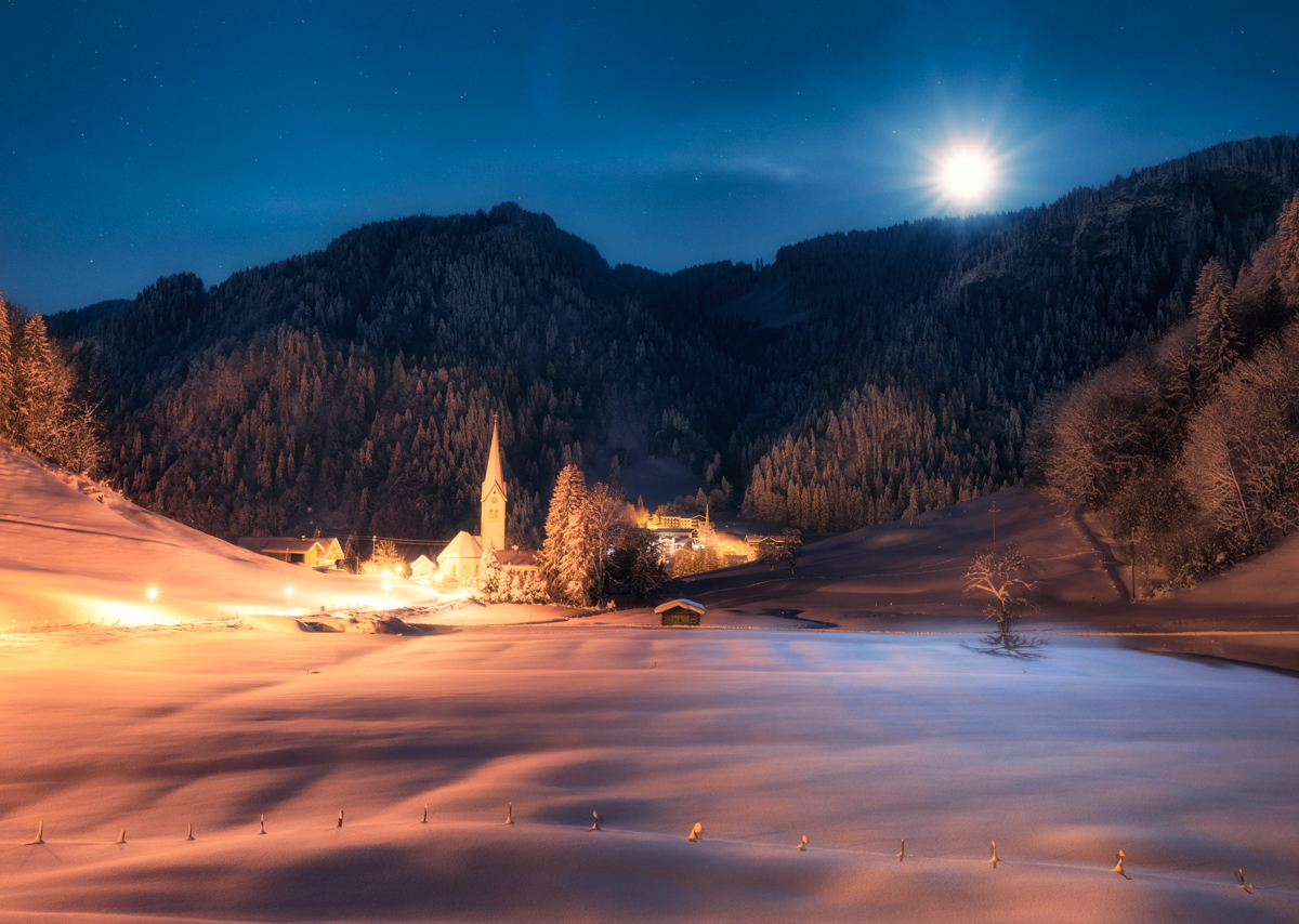 Vollmond über Tiefenbach bei Oberstdorf, Verschneites Bergdorf mit Kirche im Mondschein, Weihnachtliche Winternacht