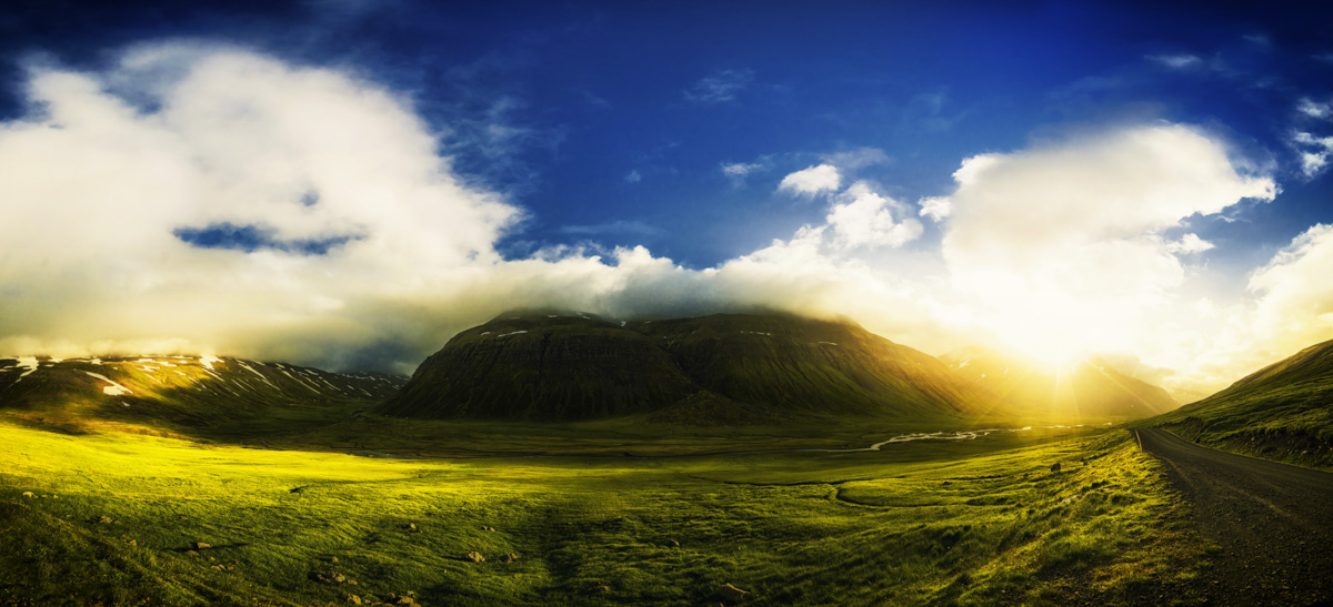 Bergpanorama mit Sonnendurchbruch, Grüne Wiesen und dramatische Wolken, Weite - Landschaftsfotografie Island