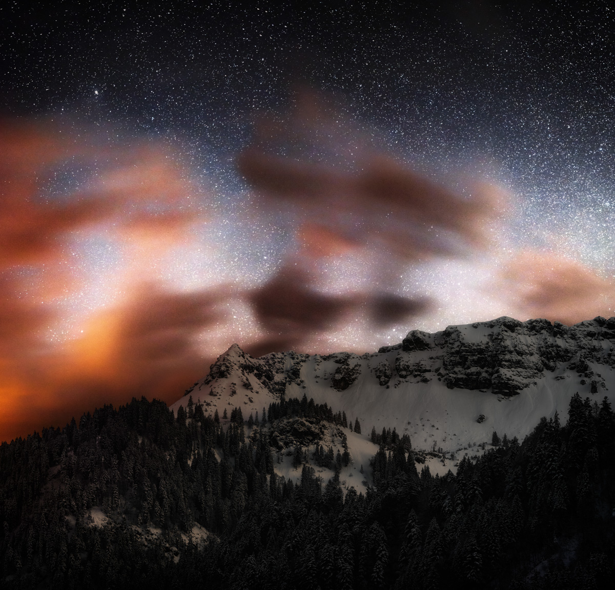 Milchstraße über Hinterstein im Winter, Sternenhimmel mit ziehenden Wolken, Astrofotografie im Allgäu