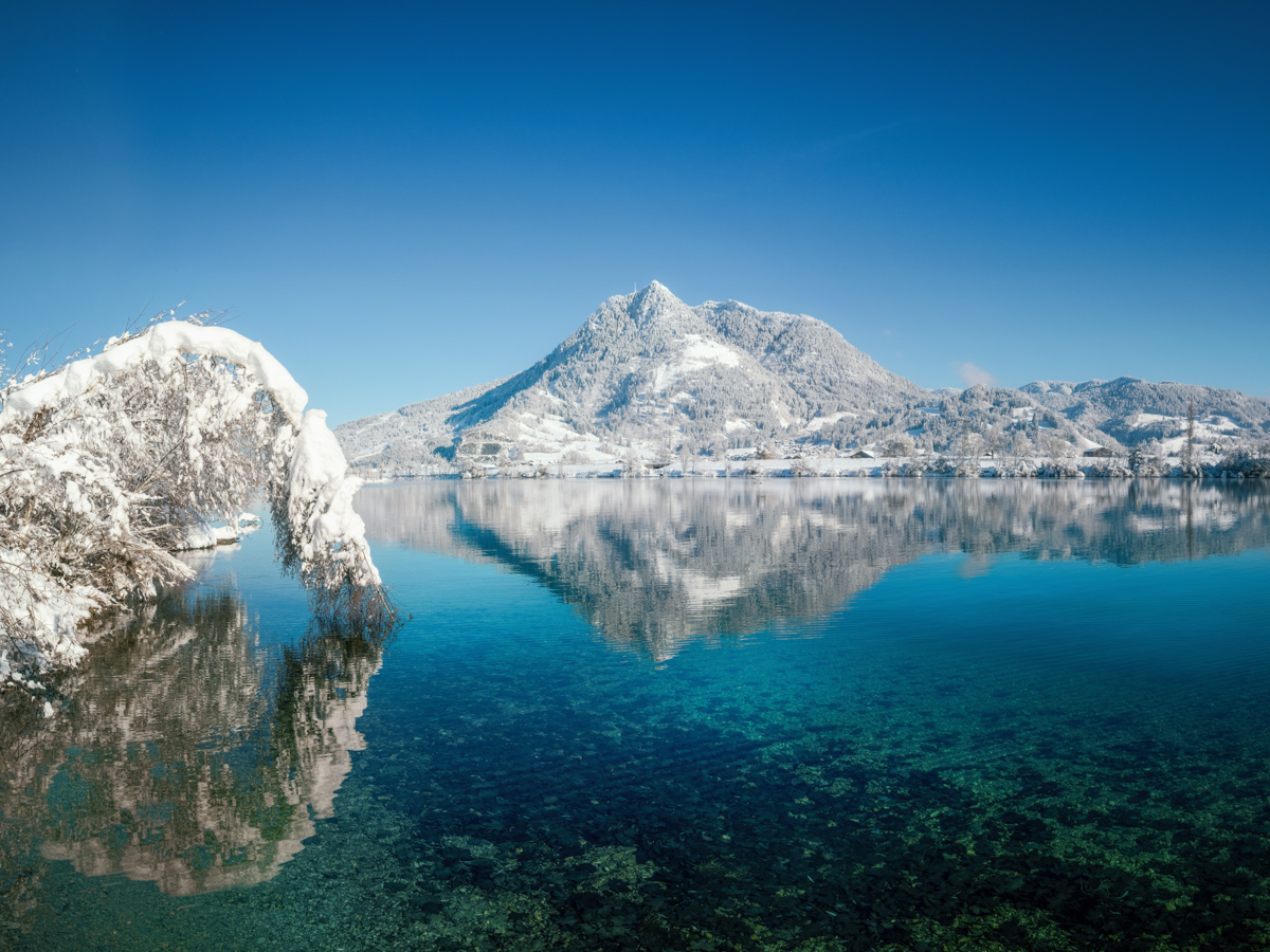 Ortwanger See im Winter mit türkisfarbenem Wasser, Kristallklarer Bergsee vor verschneitem Berg, Allgäuer Winterjuwel