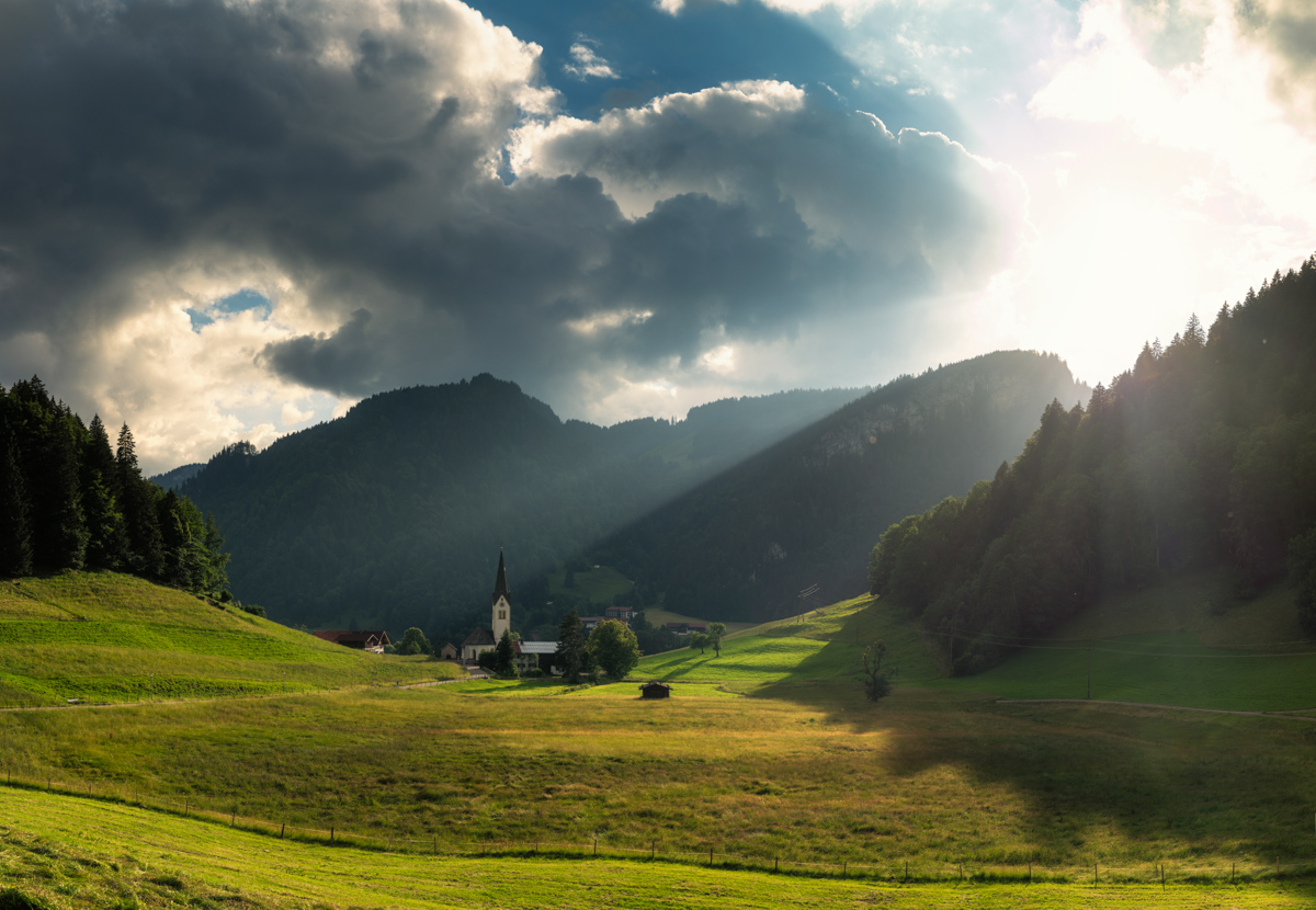 Oberstdorf, Dorfkirche im Sonnenlicht, Bergtal mit Wolkenstimmung - Landschaftsfotografie Oberallgäu