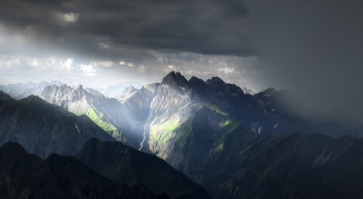 Godrays über der Trettach, Lichtstrahlen durchbrechen Gewitterwolken am Nebelhorn, Naturschauspiel Oberstdorf - Oberallgäu