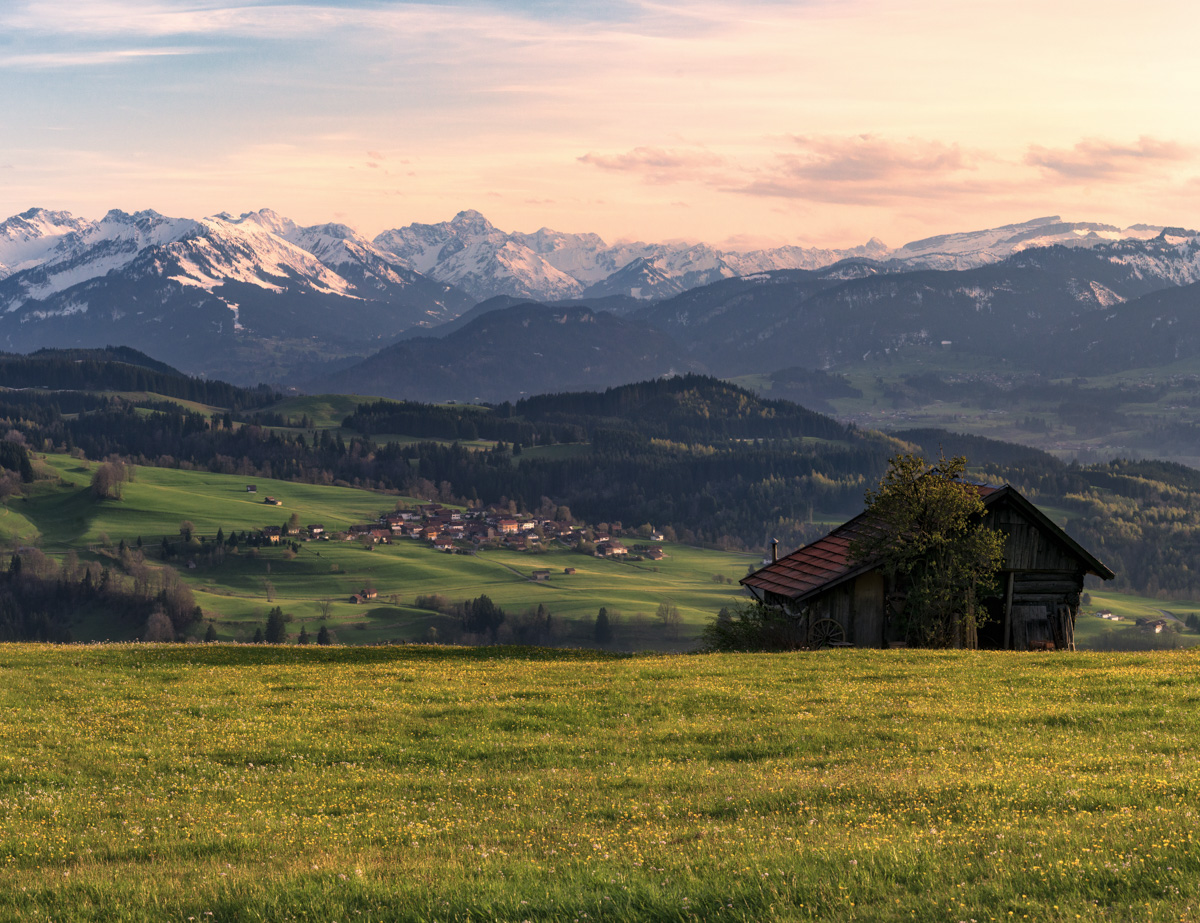 Allgäuer Bergpanorama bei Hindelang, Heustadel vor Alpenkette im sanften Abendlicht, Frühlingszauber Oberallgäu