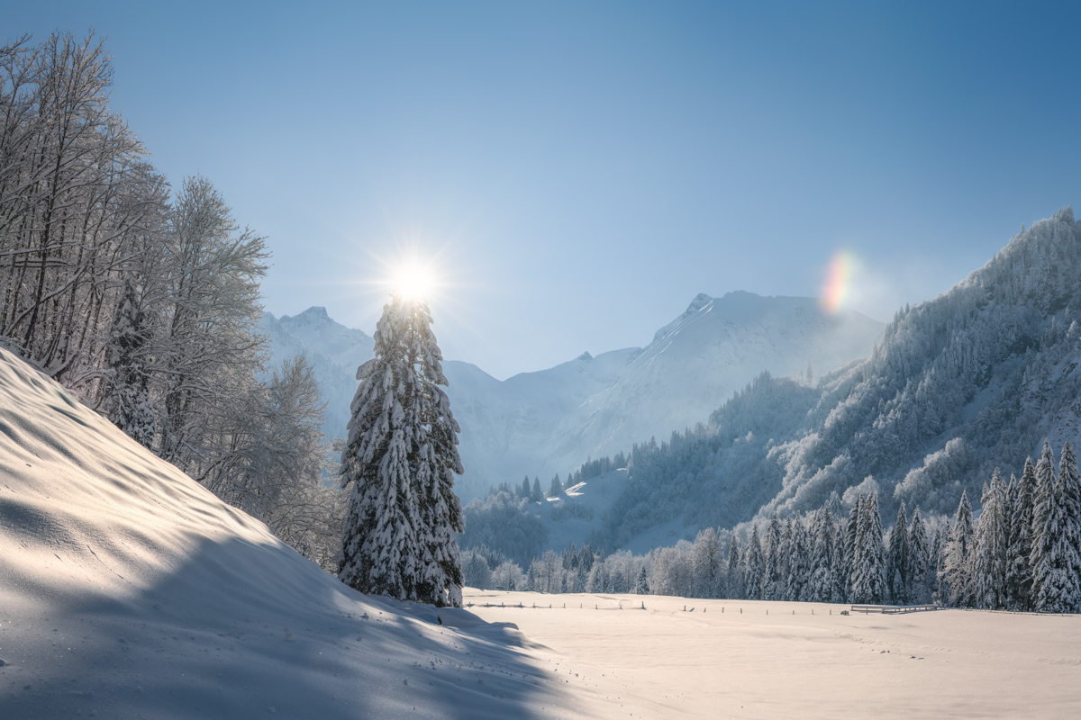 Spielmannsau Trettachtal Wintermärchen im Sonnenlicht, Verschneites Tal mit Sonnenstern und Regenbogeneffekt bei Oberstdorf