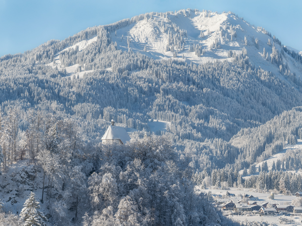 Schöllanger Burg Wintermärchen, Verschneites Dorf mit Kirche vor Skiberg, Fischen Allgäu