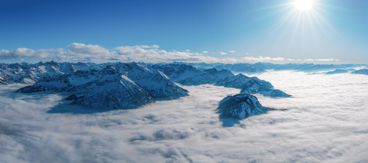Breitenberg über dem Nebelmeer, Winterliches Wolkenmeer mit Sonnenstern bei Bad Hindelang, Oberallgäu über den Wolken