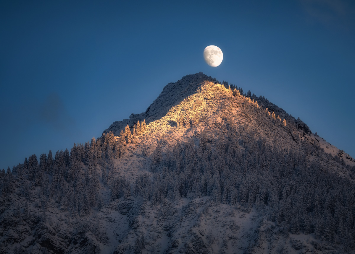 Vollmond über dem Schattenberg bei Oberstdorf, Mondaufgang über verschneitem Gipfel im goldenen Abendlicht, Wintermagie