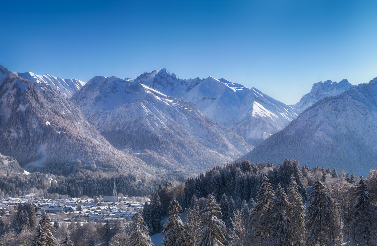 Oberstdorf im Winterkleid, Verschneites Bergdorf mit Kirchturm, Sonniger Wintertag im Allgäu - Landschaftsfotografie Allgäu