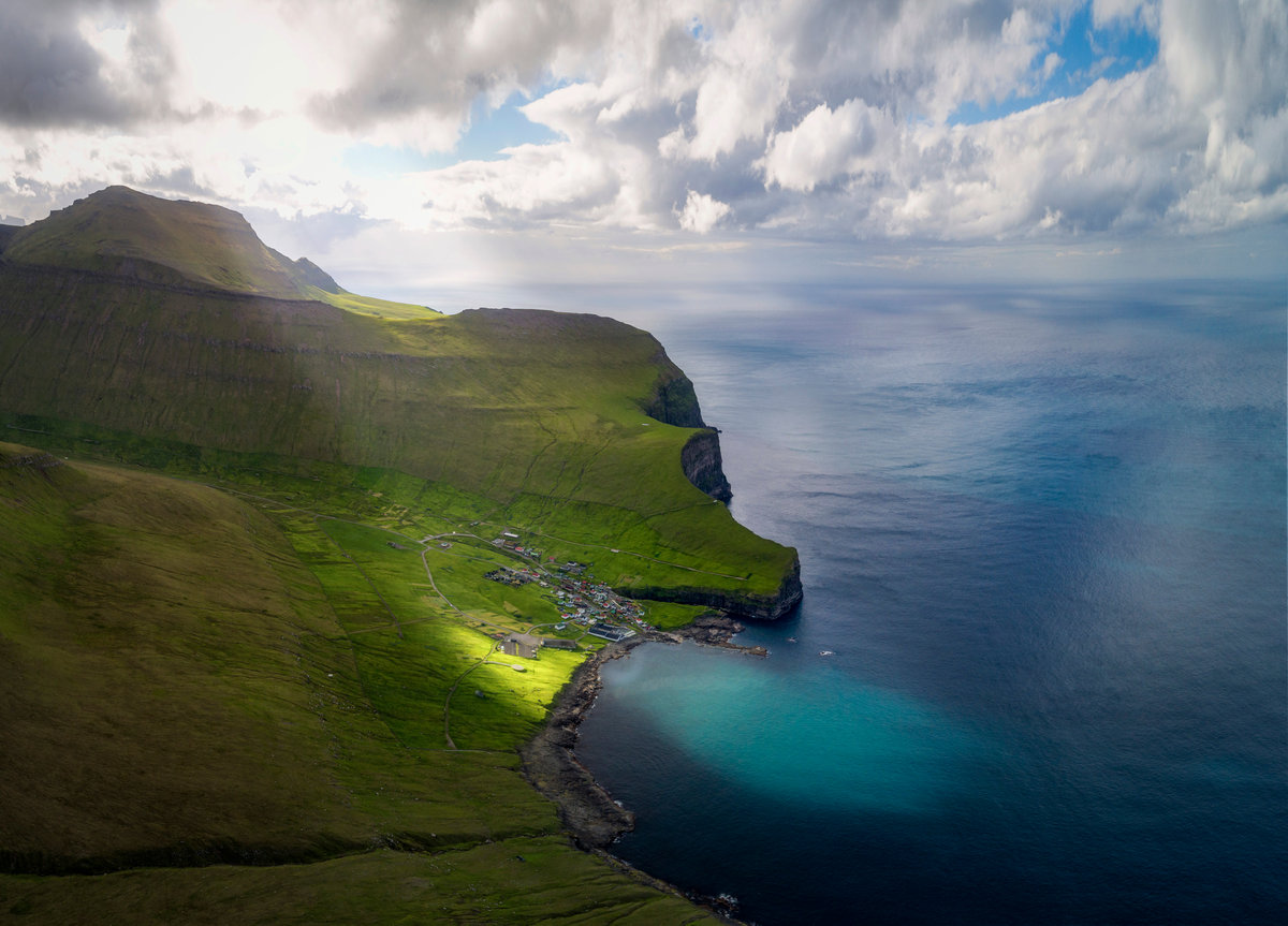 Gjógv Färöer Inseln | Grünes Dorf zwischen Steilklippen mit türkisblauer Bucht auf Eysturoy | Lichtspiel an der Küste - Drohnenfotografie Färöer