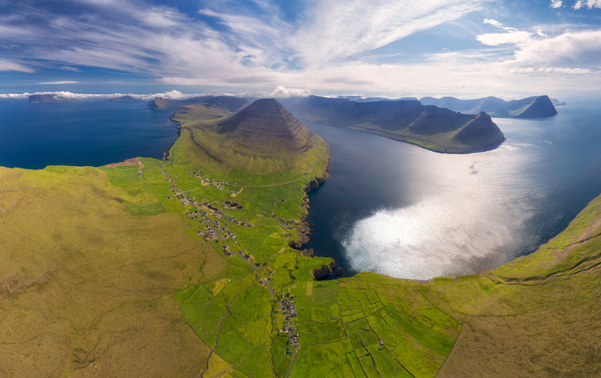 Färöer | Luftaufnahme einer grünen Bucht mit Schichtberg und Dorf | Panoramische Insellandschaft - Drohnenfotografie Färöer-Inseln